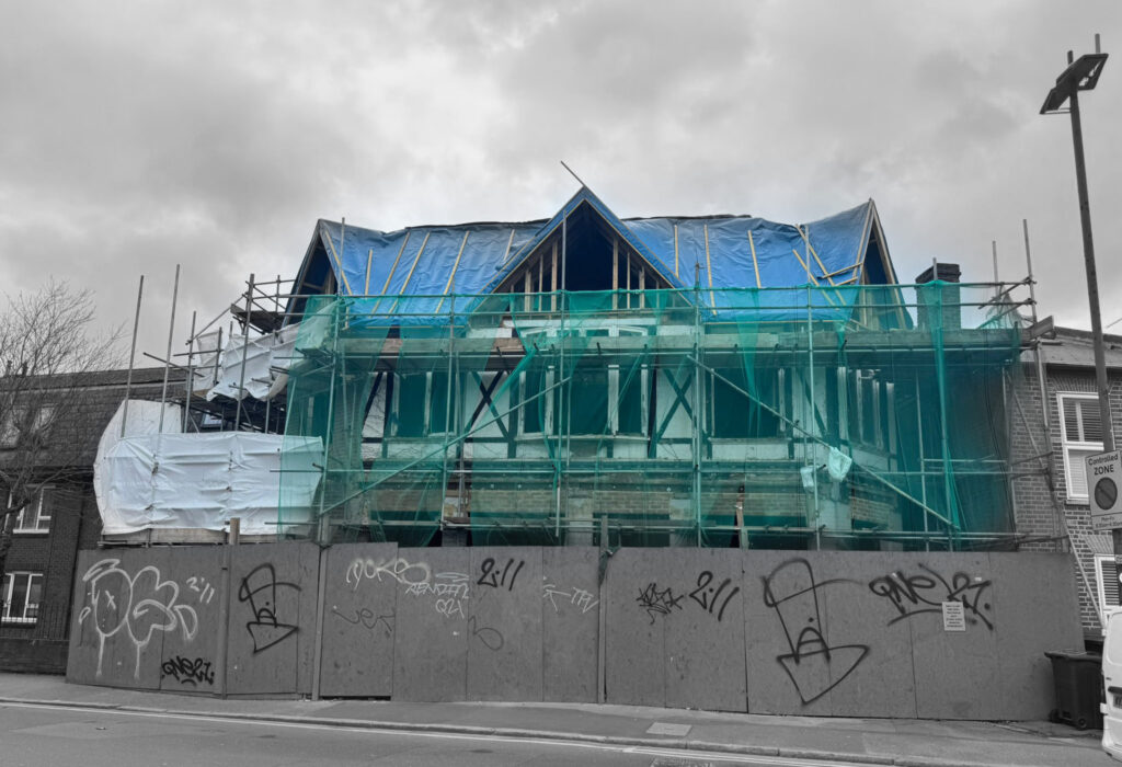 Structural steel frame and façade under construction on a London development, illustrating construction interface coordination between structure and envelope